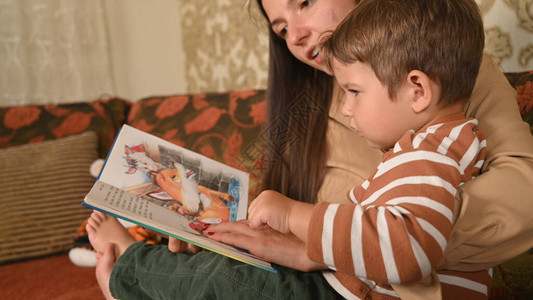 母亲和孩子看一本书中的图片图片