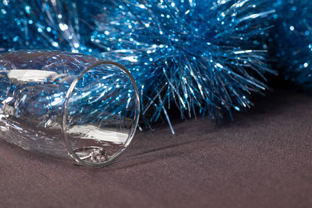在一个香槟杯中订婚戒指在蓝色闪亮的圣诞树罐子附近背景图片