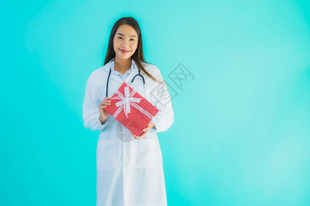 肖像美丽的年轻亚洲医生女与蓝色孤图片