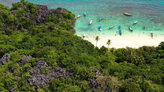 沙滩与游客和热带岛屿的珊瑚礁环图片