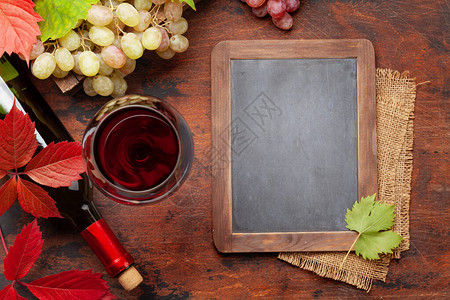 在木制桌上的红酒和葡萄图片