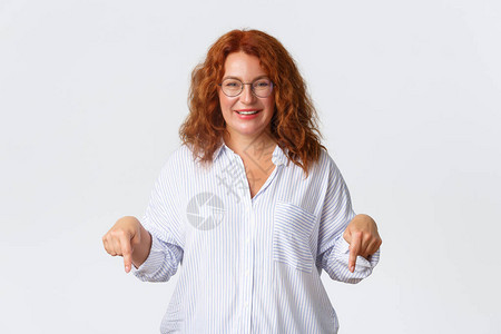 戴眼镜的愉快友好的中年红发女肖像提供建议图片