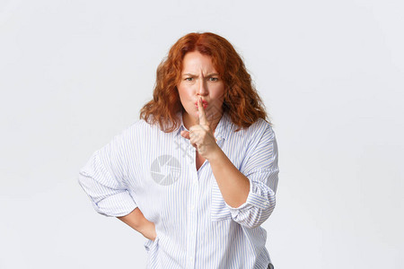愤怒和困扰的中年红发女人嘘声和皱眉图片