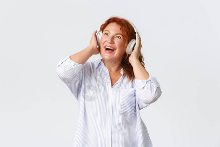 中年红发妇女对耳机的响声感到非常惊讶图片