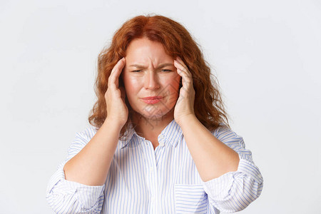 人情感和生活方式的概念女感到头晕或不适因头痛而做鬼脸触摸太阳穴偏头痛需要止痛药站立白色背背景图片