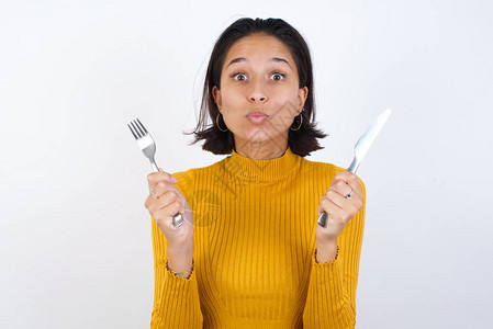 饿着肚子的女孩握在手叉刀里想吃图片