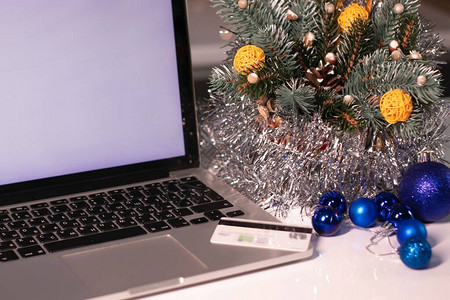 新年装饰品附近有白屏幕和信用卡的笔记本电脑圣诞购图片