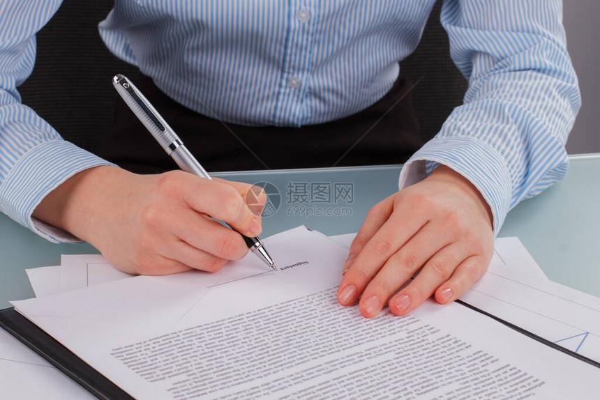 商业妇女亲手在办公室签署一份法律文件图片