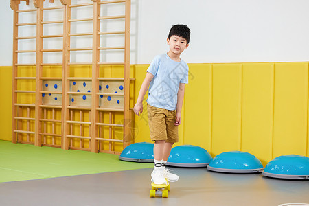 室内玩滑板的可爱男孩图片