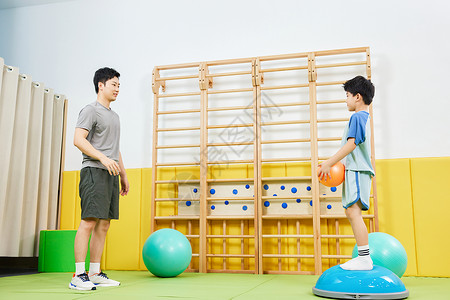 男教练指导小男孩一起玩抛球游戏背景图片