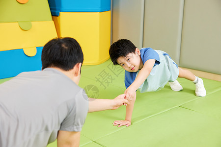体能儿童教练指导小男孩做俯卧撑背景