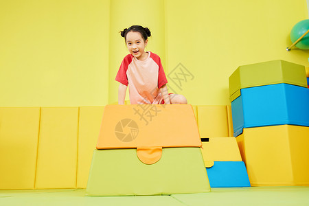 运动金字塔玩跳马游戏的小女孩背景