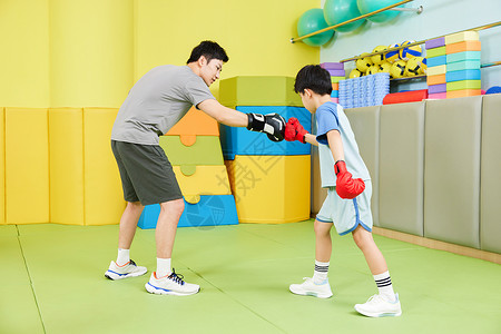 游戏代练小男孩和教练一起进行拳击训练背景