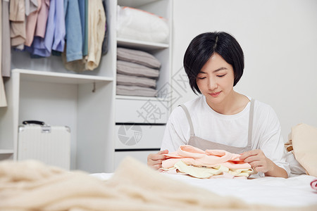 女衣服收纳衣物的女收纳师背景