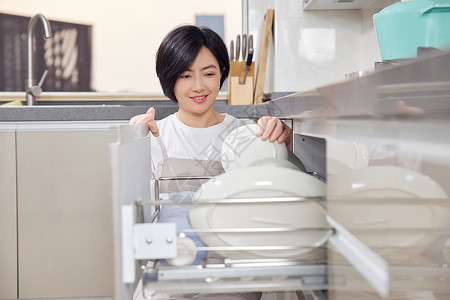 青年女性整理厨房碗柜高清图片
