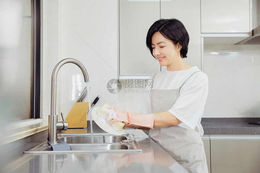 青年女家政厨房洗碗刷碗图片