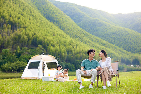 陪伴孩子户外露营的年轻夫妻图片