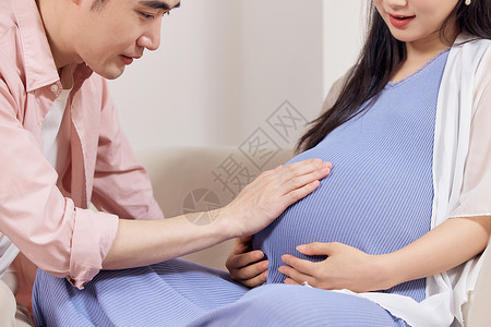 丈夫贴着妻子孕肚感受胎动背景图片