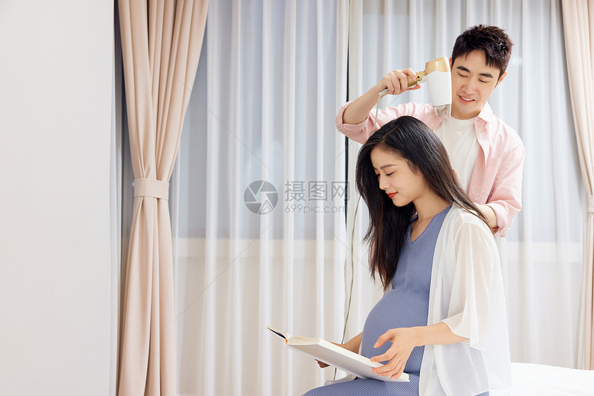 青年丈夫为怀孕的妻子吹头发图片