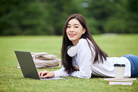 草坪上电脑学习的女学生图片