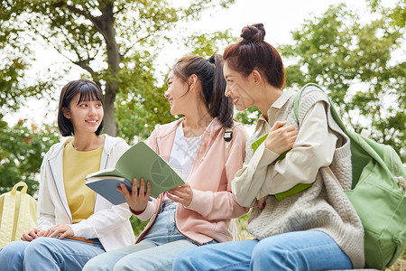 世界坐女大学生们坐在一起看书背景