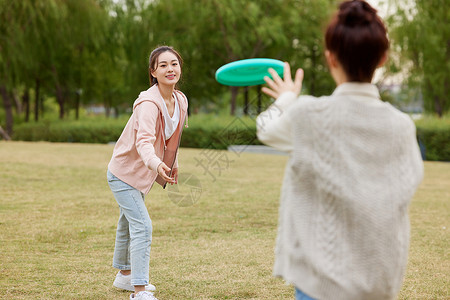 秋季在户外玩飞盘的女性高清图片