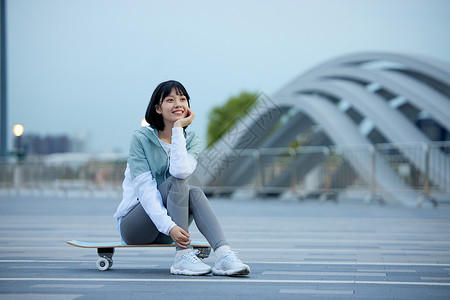户外玩滑板的青年女性图片
