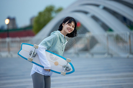 户外玩滑板的年轻女性背景图片