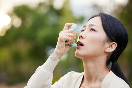 室外女性使用哮喘喷雾治疗图片
