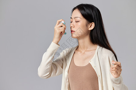 使用哮喘喷雾的女性图片