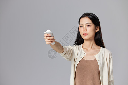 手拿耳温枪的女性背景图片