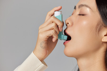 冬季润唇膏生病的女性使用哮喘喷雾背景