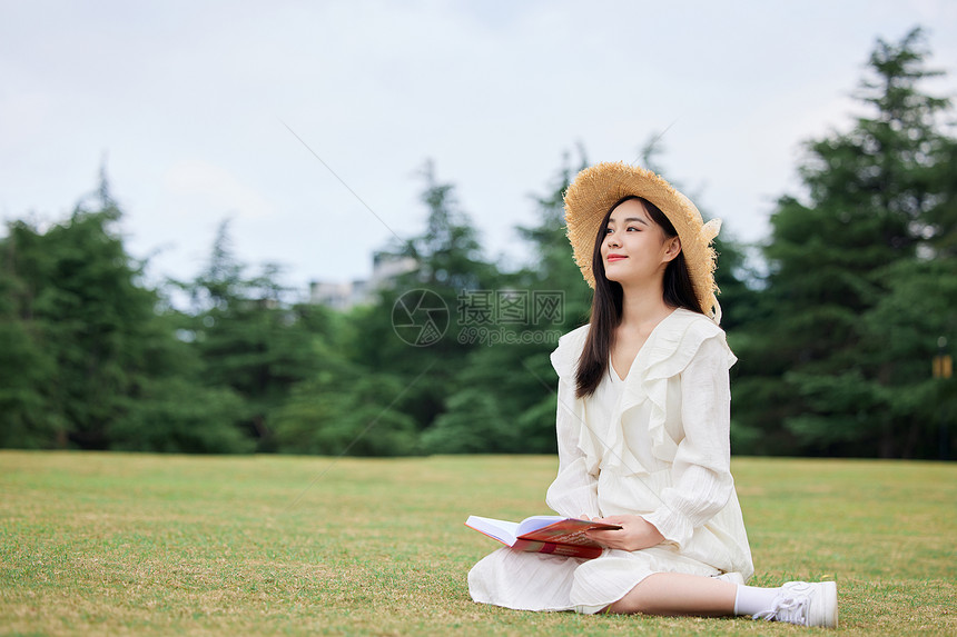 年轻美女户外草坪放松阅读图片