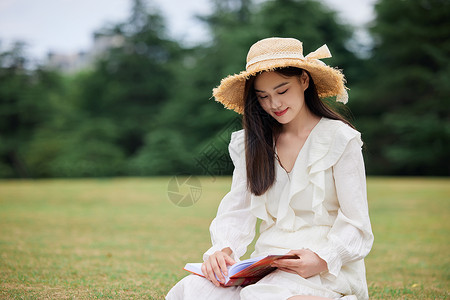 年轻美女户外草坪阅读图片