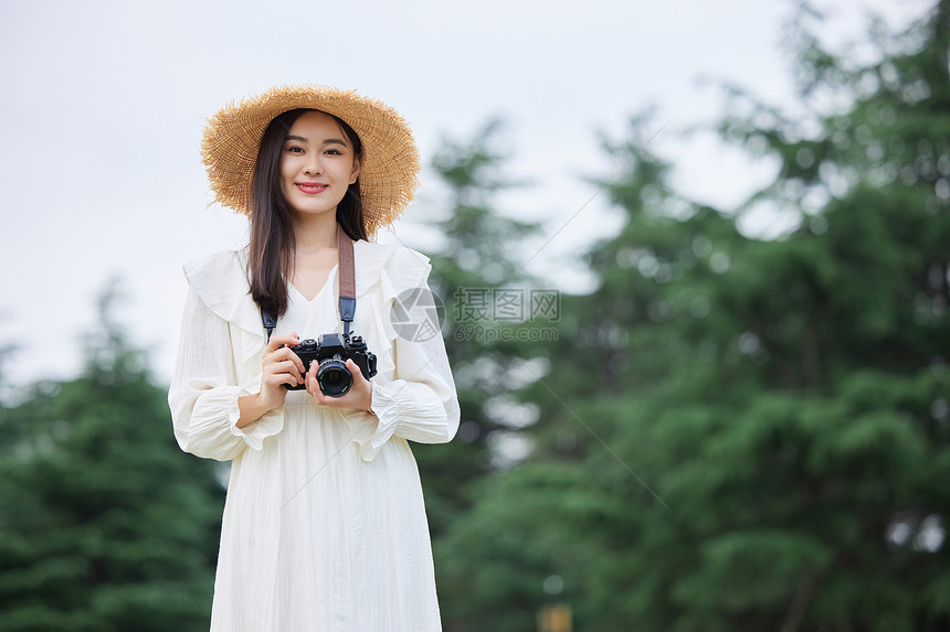 手拿相机拍照的文艺美女图片