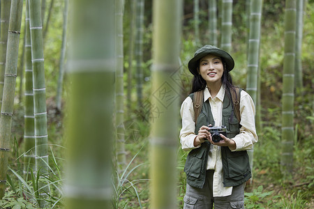 户外徒步拍照的青年女性背景图片