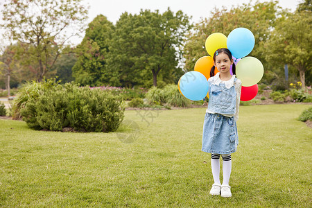 室外草地上手拿气球的小女孩图片