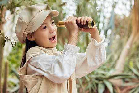 在植物园使用望远镜游玩的小女孩图片