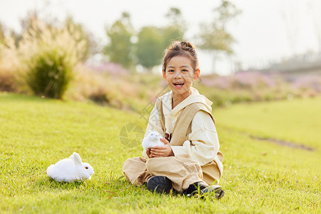室外和兔子玩耍的小女孩背景图片