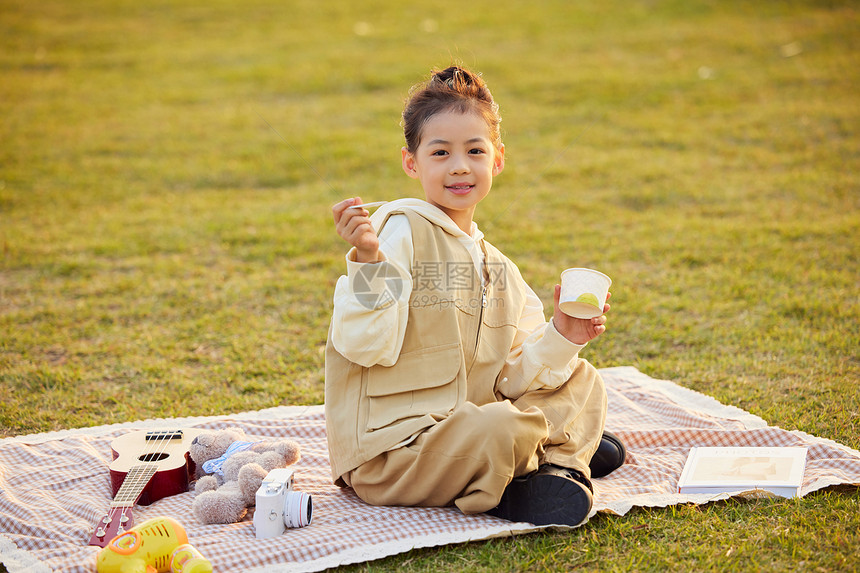 室外草地上野餐的小女孩图片