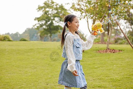 秋季室外玩泡泡机的小女孩背景图片