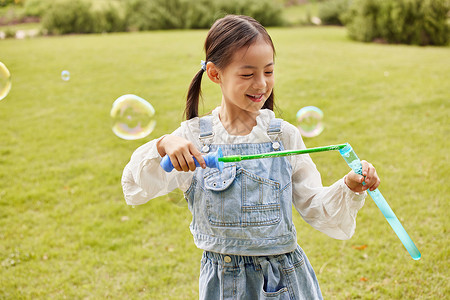 秋季室外玩耍吹泡泡的小女孩背景图片
