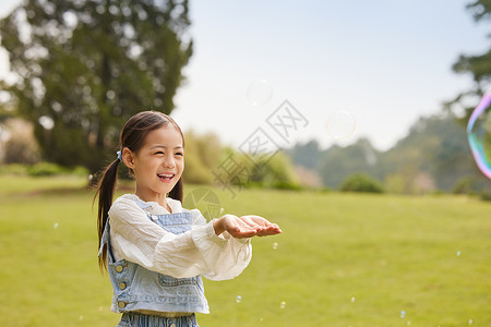 金色泡泡小女孩用手接泡泡背景