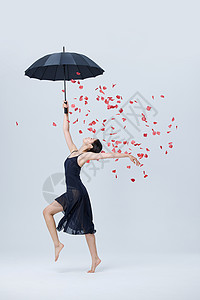 美女撑伞舞蹈花瓣飘落背景图片