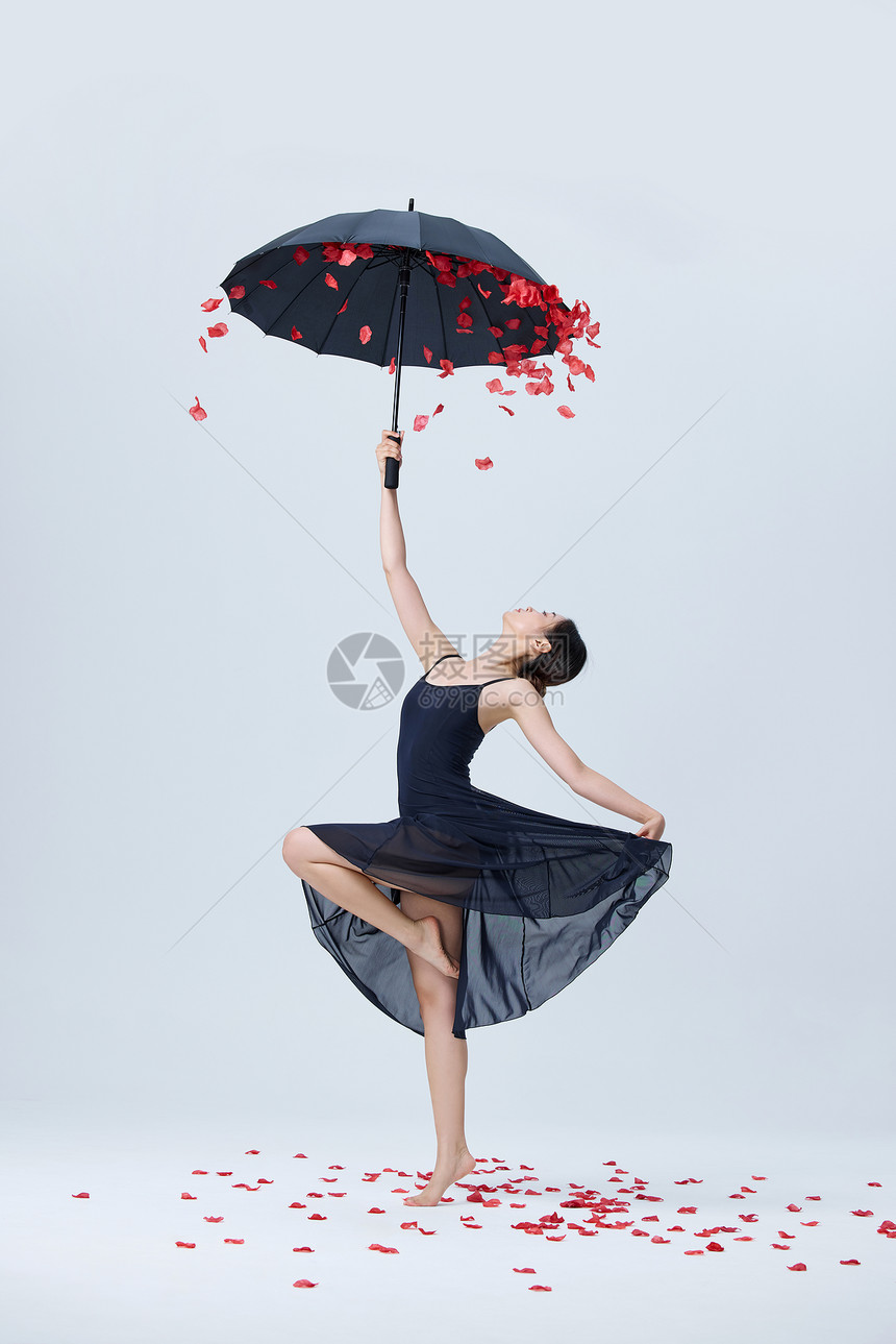 美女撑伞舞蹈花瓣飘落图片