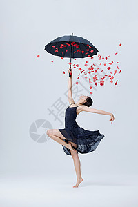撑伞花瓣舞蹈的女性高清图片