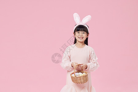 手拿彩蛋篮子的兔耳朵女孩背景图片