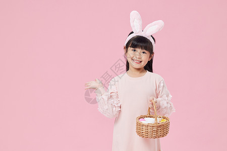 手拿彩蛋篮子的可爱兔耳朵女孩背景图片