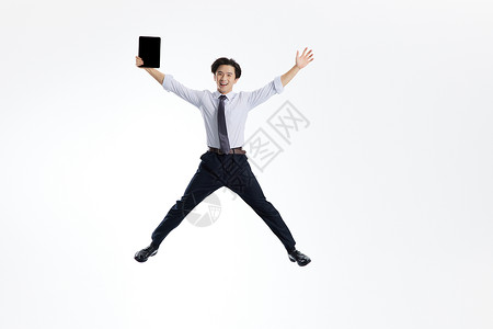 跳跃的商务男士手拿平板电脑形象图片