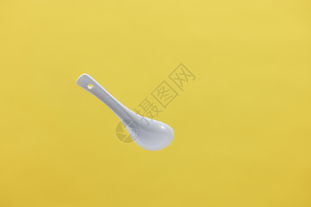 空中漂浮的白色陶瓷勺子背景图片